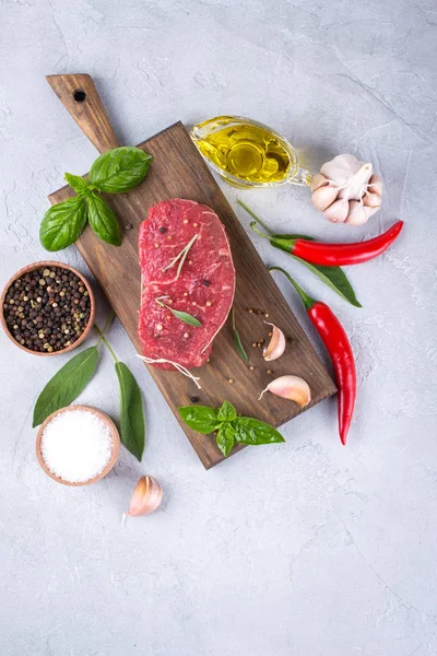 Çiğ et. Bir kesme tahtası Yeşiller ve baharat ile ham sığır eti biftek.