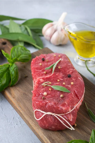 Çiğ et. Bir kesme tahtası Yeşiller ve baharat ile ham sığır eti biftek.