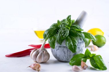 Taze Bahçe basil otlar harç ve zeytinyağı, sarımsak, kırmızı biber, limon beyaz arka plan üzerinde sıcak..