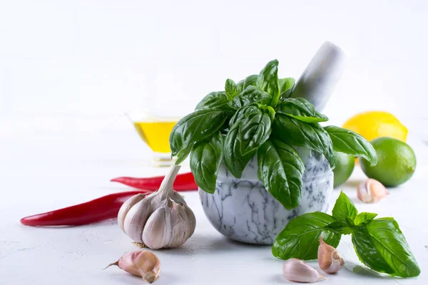 Taze Bahçe basil otlar harç ve zeytinyağı, sarımsak, kırmızı biber, limon beyaz arka plan üzerinde sıcak..