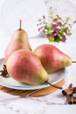 Taze, olgun organik tatlı armut tabak tarçın, Anason yıldız ve ballı beyaz mutfak masası üzerinde. 