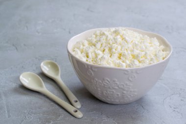 Seramik kaşık ile ev yapımı Peynir tabağı. Gri beton zemin üzerine.