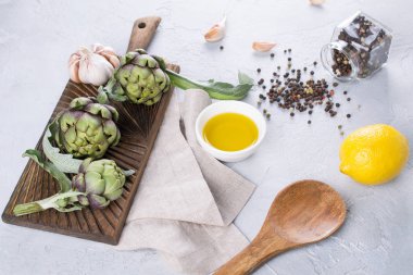 Yönetim Kurulu hazır yemek ve malzemeler için sarımsak, limon ve zeytin yağı kesme üzerinde taze olgun yeşil enginar