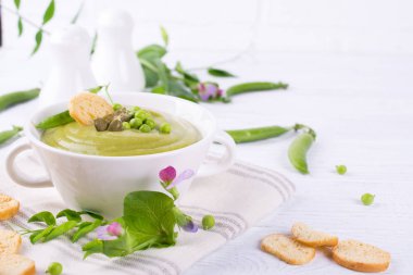 Kabak çekirdeği, beyaz arka plan üzerinde kruton ile hafif yaz yeşil bezelye krem lezzetli çorba servis.