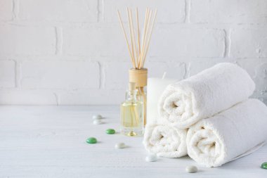 Spa aromaterapi arka plan. Natürmort beyaz havlu, banyo yağı, Masaj fırça ve mum.