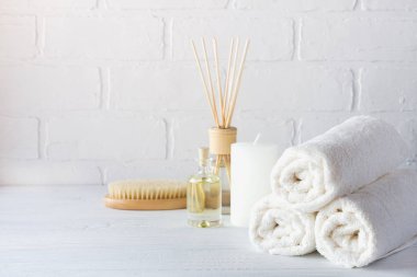 Spa aromaterapi arka plan. Natürmort beyaz havlu, banyo yağı, Masaj fırça ve mum.
