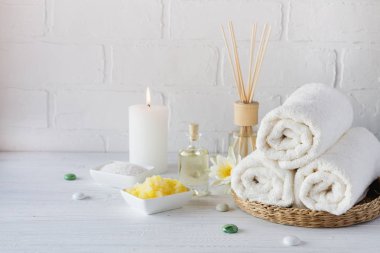Spa natürmort havlu, beyaz zambak, deniz tuzu, banyo yağı, şeker vücut fırçalayın ve mum 