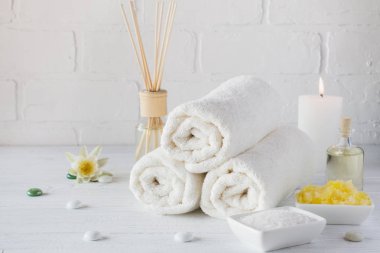 Spa natürmort havlu, beyaz zambak, deniz tuzu, banyo yağı, şeker vücut fırçalayın ve mum 