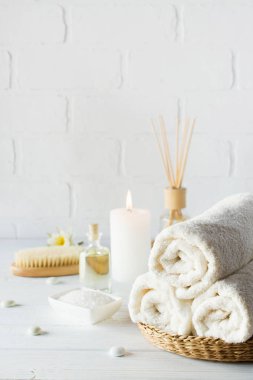 Spa aromaterapi arka plan. Natürmort beyaz havlu, banyo yağı, Masaj fırça ve mum.