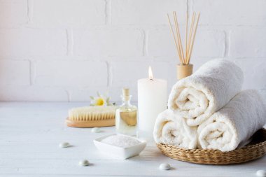 Spa aromaterapi arka plan. Natürmort beyaz havlu, banyo yağı, Masaj fırça ve mum.