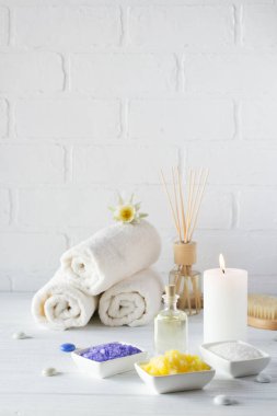 Spa natürmort havlu, beyaz zambak, deniz tuzu, banyo yağı, şeker vücut fırçalayın, Masaj fırça ve mum 