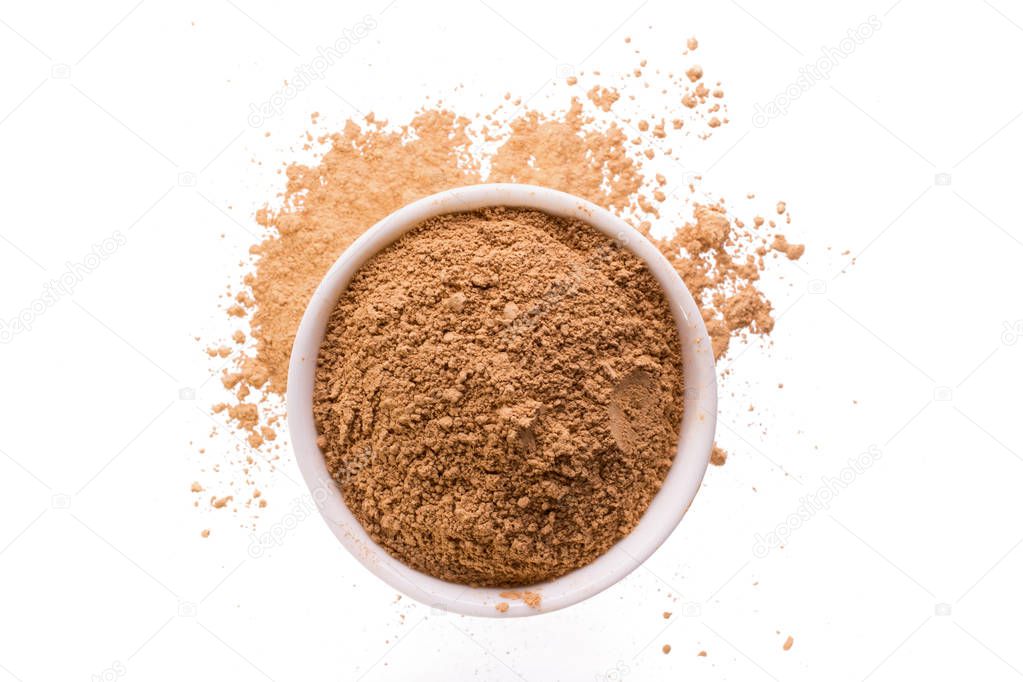 Dry yellow clay powder mask for face and body  in ceramic bowl isolated on white