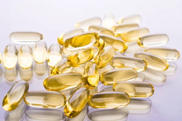 Capsules of fish fat oil on a white background with space for text