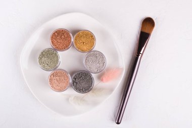 Beyaz arkaplanda farklı kozmetik çamur tozları.