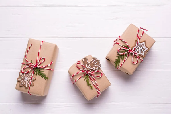 Eco craft holidays gift boxes tied with red and white string on black background mock up