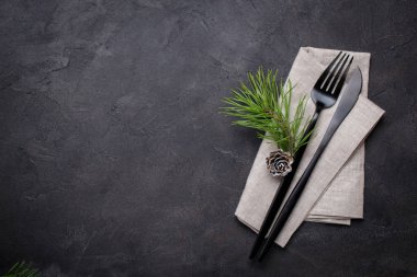 Noel menü kavramı. Xmas süslemeleri ve çam kozalakları, karanlık çatal ve peçete ile ayarla bıçak düz yatırın. Kopya alanı