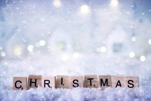 Christmas word from letters on winter background with snow and lights. Template, greeting card. Selective  soft focus Holiday concept.