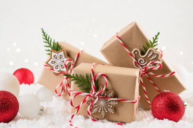 Noel arka plan. Beyaz Kış arka plan üzerinde kırmızı ve beyaz iple bağlı kahverengi kraft kağıt parsel