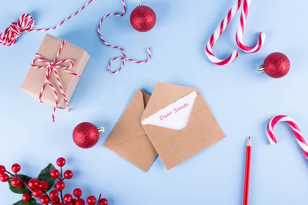Letter to Dear Santa. Craft envelopes on christmas holiday background. Flat lay.