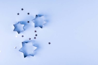 Tatil arka plan. Grup mavi pastel arka plan üzerinde küçük gümüş yıldız. Üstten görünüm. Kopya alanı.