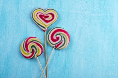 Renkli çizgili lolipop düz en az kavramı turkuaz kopya alan arka plan üzerinde yatıyordu.