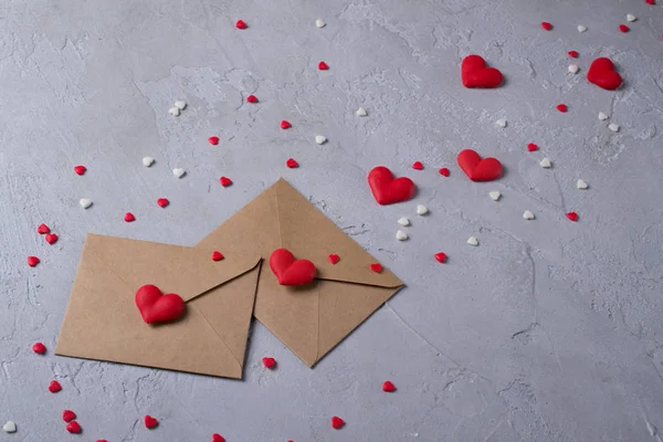 İki el sanatları çok renkli tatlı şeker şeker kalpler ile posta zarf kağıt. Aşk mesajı ya da hediye kavramı.