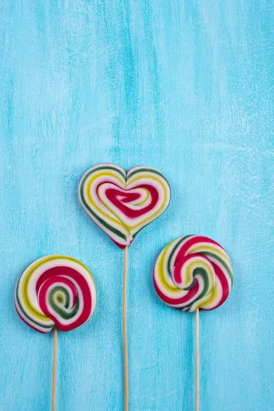 Renkli çizgili lolipop düz en az kavramı turkuaz kopya alan arka plan üzerinde yatıyordu.