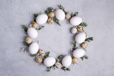 Paskalya kartı veya davet için daire sınır. Paskalya çelenk Paskalya bıldırcın, tavuk yumurtası ve okaliptüs yaprağı dal. Gri beton ile bir arka plan üzerinde metin için yer.