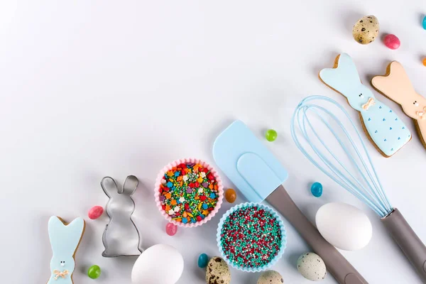 Preparation of gingerbread cookies. Easter cookies in the shape of  a  funny  rabbit , tools necessary to make gingerbread pastry, colored sprinkles. Easter concept.
