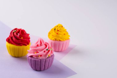 Dekoratif renkli şeker cupcakes sprinkles ile ışık arka plan üzerinde