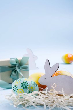 Paskalya tatili arka plan ile yumurta. Renkli boyalı tavuk yumurtası, Beyaz ahşap tavşan ve kurdele ile mevcut kutusu. Paskalya tatili dekor kompozisyon