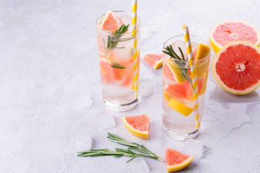 Greyfurt limonata. İki kadeh içki, serinletici su greyfurt, biberiye dalları ve buz ile. Tarifi kavramı, kokteyl
