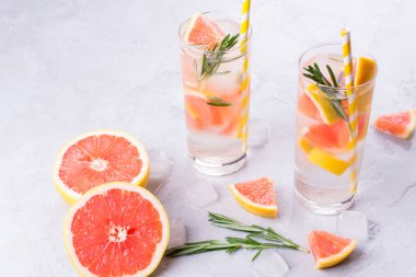 Greyfurt limonata. İki kadeh içki, serinletici su greyfurt, biberiye dalları ve buz ile. Tarifi kavramı, kokteyl