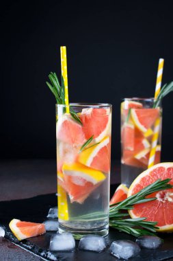Greyfurt limonata. İki kadeh içki, serinletici su greyfurt, biberiye dalları ve buz ile. Tarifi kavramı, kokteyl