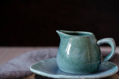 Doğal el işi dishware. Ahşap kahverengi kesme tahtası ve gri kumaş peçete ile seramik mavi krem kabı. Ülke, rustik tarzı