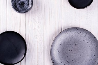 Porselen kümesi elişi gri ve siyah ve beyaz ahşap bir masa üzerinde kase. Düz yatıyordu