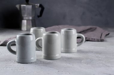 Gri rustik kahve fincan el sanatları ve şofben kahve makinesi eski püskü gri duvara kümesi. Doğal el yapımı çanak çömlek sofra