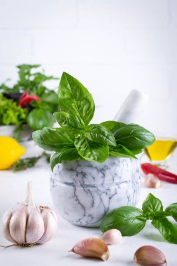 Taze Bahçe basil otlar harç ve zeytinyağı, sarımsak, kırmızı biber, limon beyaz arka plan üzerinde sıcak..