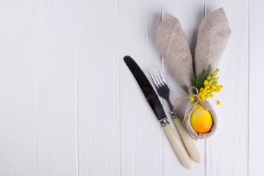 Menü için Paskalya arka plan bahar. Paskalya yumurtası dekorasyon, tavşan kulakları keten peçete ve mutfak bıçakları Beyaz ahşap tablo