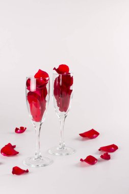 İki bardak beyaz zemin üzerine gül yaprakları ile. Kutlama kavramı. Metin için yer kopyalayın