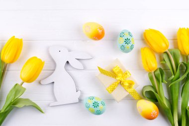 Mutlu Paskalya kartı. Sarı laleler ve Paskalya yumurtaları ve bunny ile kopya alanı beyaz arka plan üzerinde metin için çerçeveli. Üstten Görünüm