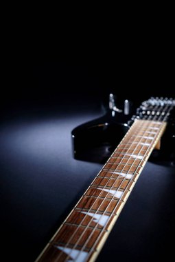 Işık demeti altında karanlık bir arka plan üzerinde Elektrik gitar Stratocaster. kopyalama alanı ile