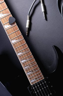 Siyah arka plan üzerinde jack kablosu ile modern siyah elektrik gitar