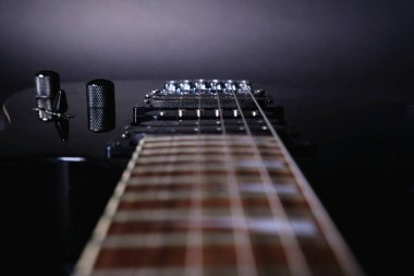 Gitar telleri ve fretboard, yakın. Elektro gitar. . Yumuşak seçici odak. Siyah arka planda