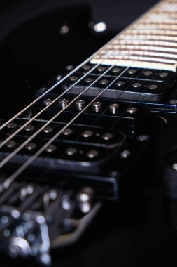 Elektro gitarın detayı. Close. Yumuşak seçici odak. Siyah arka planda
