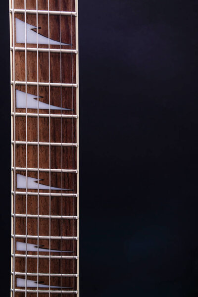 Guitar stringsand fretboard, close up. Electric guitar. .Soft selective focus. On black background with copy space