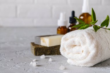 Banyo ve doğal kozmetik konsepti. Beyaz masada el yapımı sabun ve havlular. Spa ve vücut bakımı