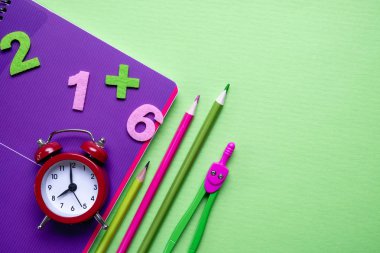 Açık yeşil kağıt arka plan üzerinde renkli farklı okul malzemeleri. Okul konseptine geri dönelim. Düz döşeme, üst görünüm, kopyalama alanı