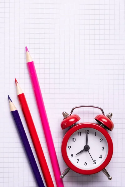 学校时间简约概念 彩色铅笔和笔记本和红色的闹钟 顶部视图 — 图库照片