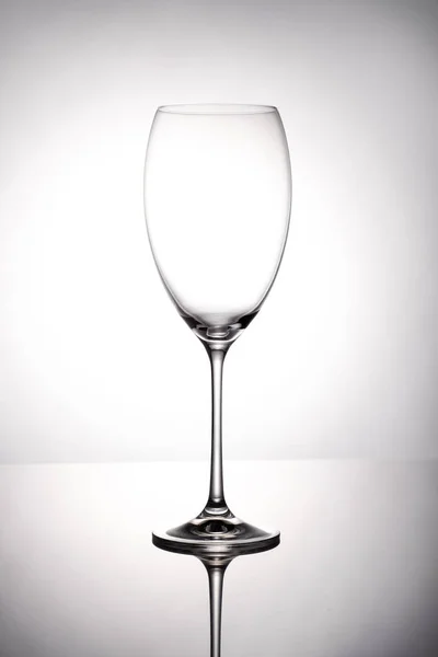 空酒杯小杯站在白色背景的镜面上 — 图库照片